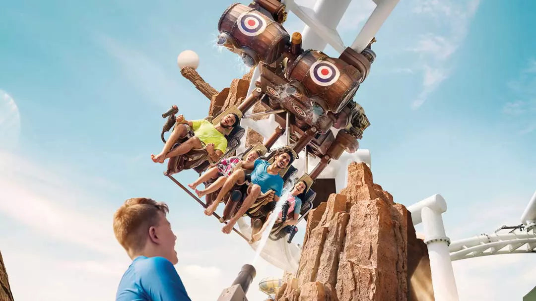 People on a roller coaster ride with a clear blue sky in the background