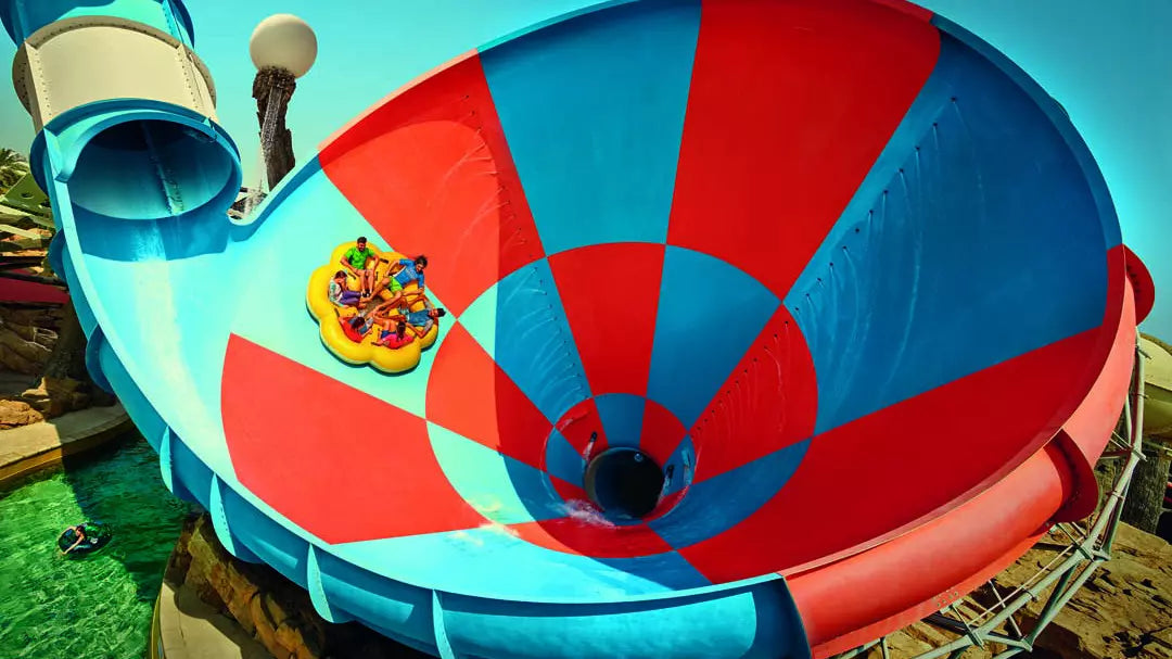 Large water slide with a red and blue design at a water park.